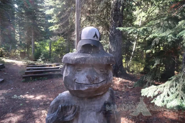 a wood carving of a bear with a hat on top of it