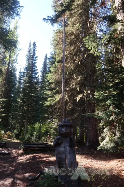 a wooden statue in a forest