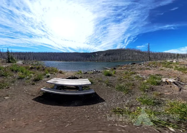 a picnic table by a lake